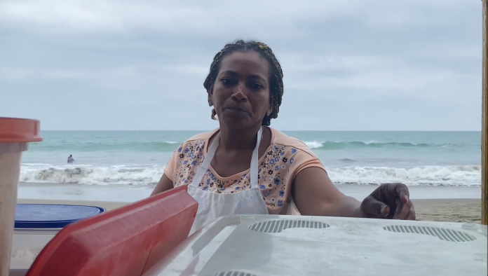 La señora Mariuxi prepara un platillo mientras espera a sus clientes.