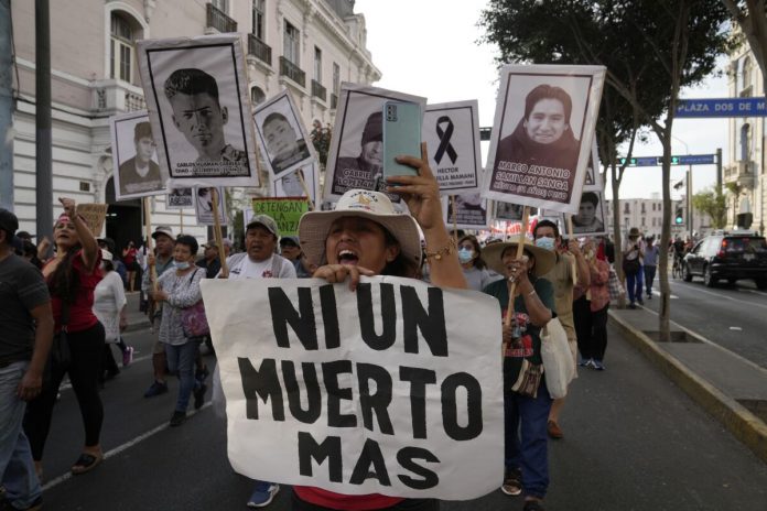 Manifestantes con carteles tras las protestas en Perú