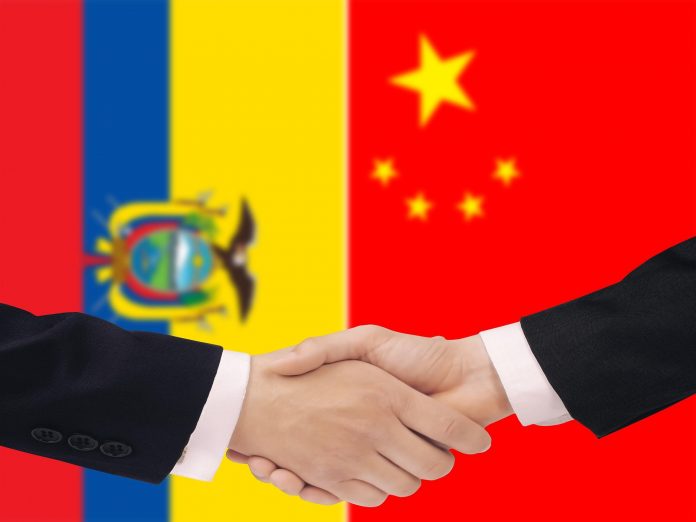 Manos en manera de aceptar un trato con bandera de Ecuador y China de fondo.