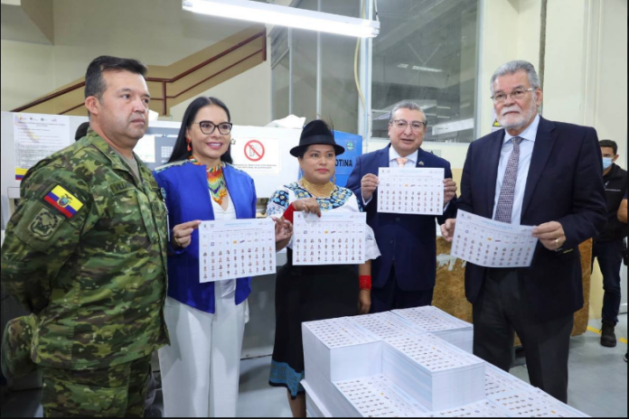 Diana Atamaint y Enrique Pita, representantes del CNE, mostrando las papeletas de las elecciones anticipadas.